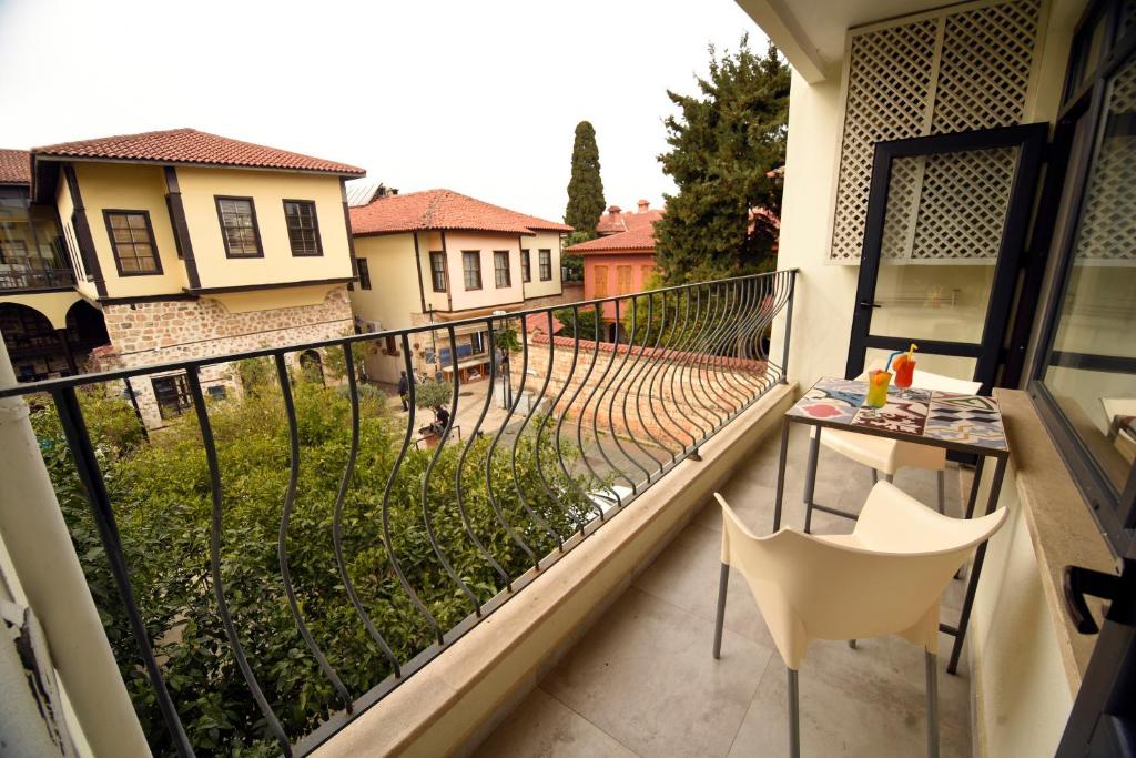 a balcony with a table and chairs and a view of a yard at Remarkable Flat with Balcony near Hadrian's Gate in Antalya