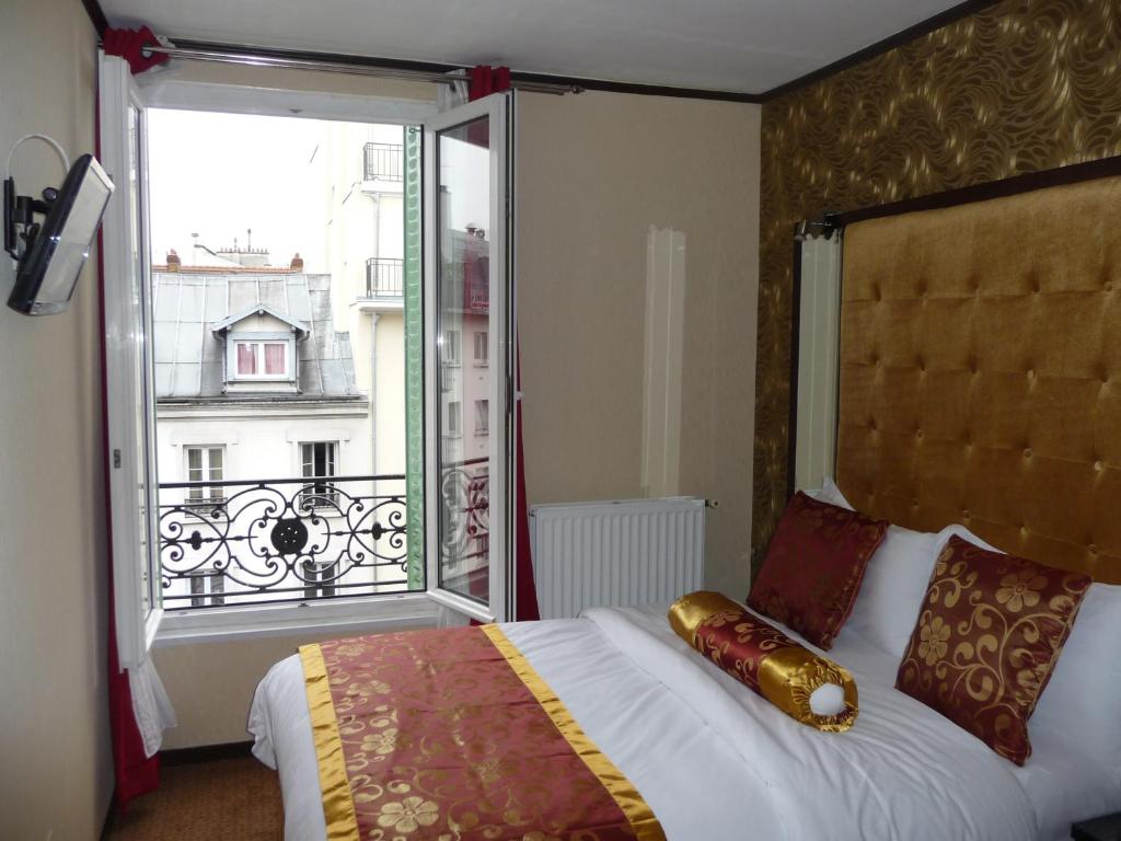 Cette chambre comprend un lit et une grande fenêtre. dans l'établissement Hôtel des Buttes Chaumont, à Paris
