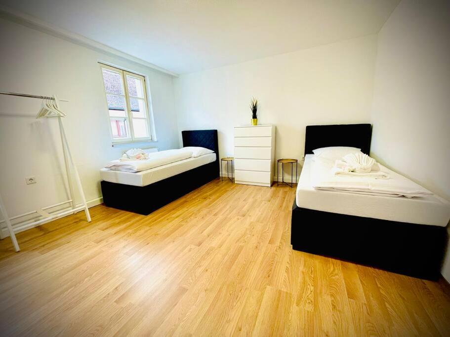een slaapkamer met 2 bedden en een houten vloer bij Apartment Goldschmied in Schwabach