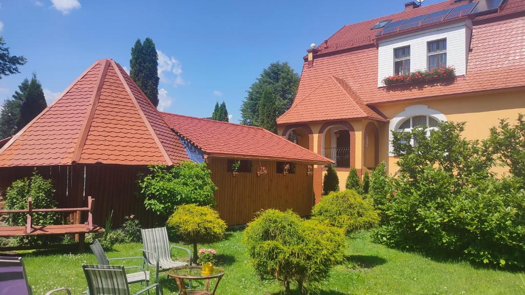 a house with a yard with chairs and a fence at Góściniec Iwona in Głuchołazy