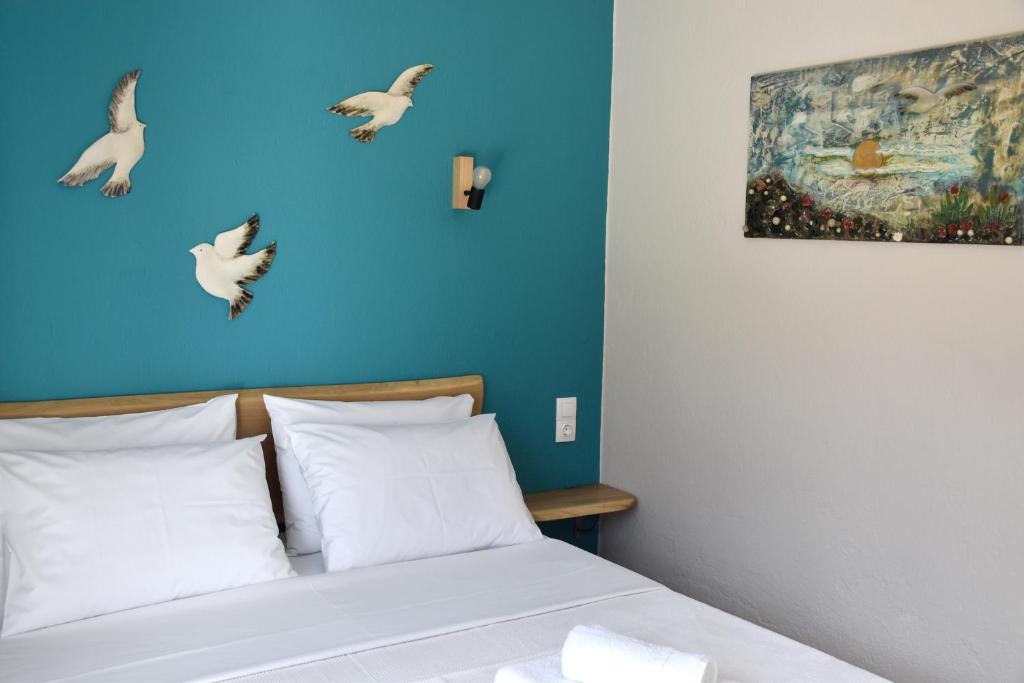 1 dormitorio con 1 cama con pájaros en la pared en ARELIA APARTMENTS IERISSOS, en Ierissos