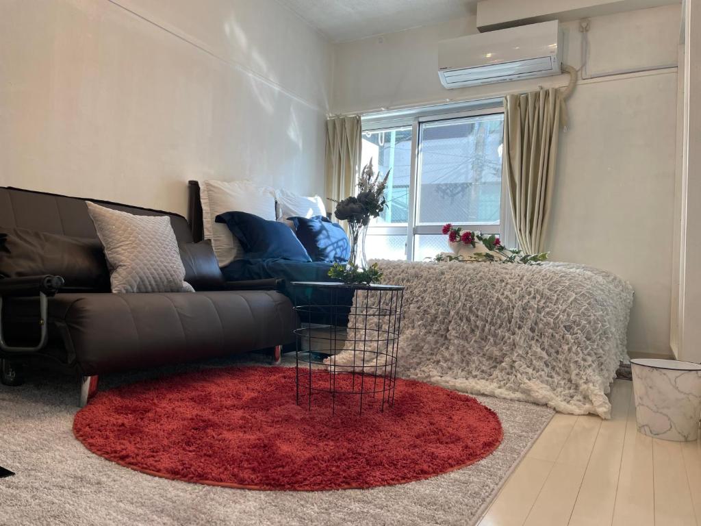 a living room with a couch and a red rug at BEST LOCATED SHINJUKU CENTRAL Full-Furnished APARTMENT 3minWalk to Station1 in Tokyo