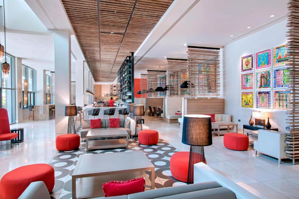 a lobby of a store with red chairs and tables at Marriott Port-au-Prince Hotel in Port-au-Prince