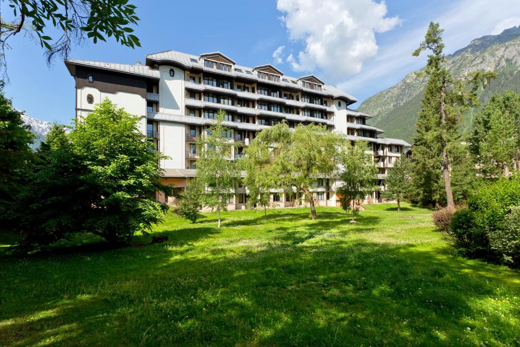 un hôtel dans les montagnes avec une pelouse verdoyante dans l'établissement Apartment Chamois Blanc 2 Centre Chamonix Mont Blanc, à Chamonix-Mont-Blanc