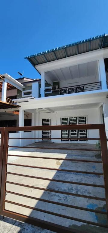 a house with a gate and stairs in front of it at Bertam Homestay Kepala Batas in Kepala Batas