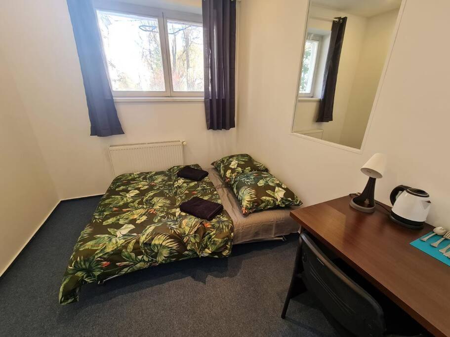 a bedroom with a bed and a desk and a desk at Fantastic Mokotow - FMG Pokoj A in Warsaw