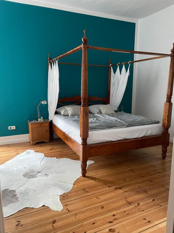 sypialnia z łóżkiem z baldachimem i niebieską ścianą w obiekcie 100qm Altbau Wohnung im Prenzlauer Berg w Berlinie