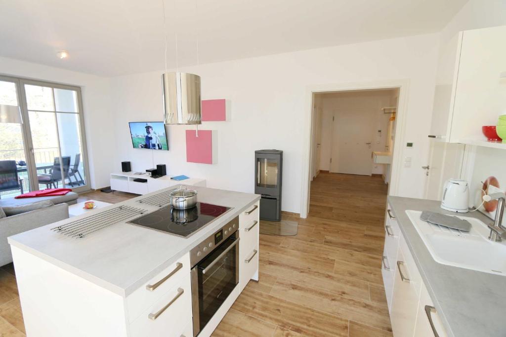 uma cozinha com bancadas brancas e uma sala de estar em Villa Pauline Whg 05 mit 2 Balkonen em Göhren