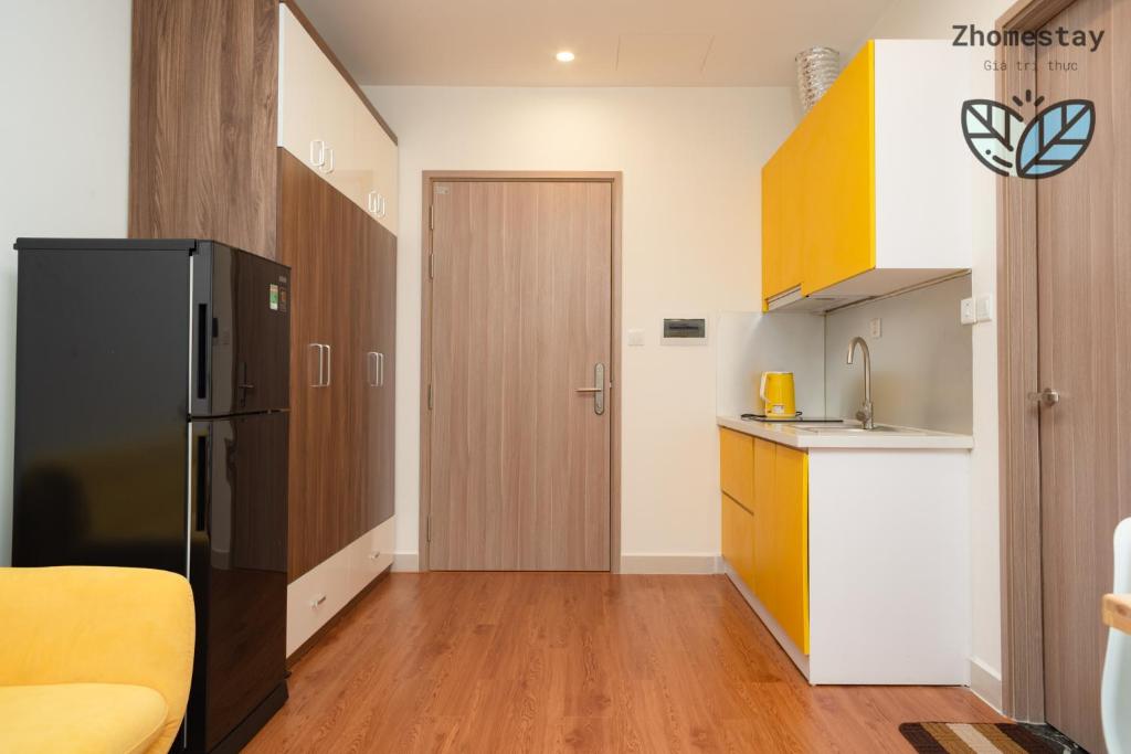 - une cuisine avec un réfrigérateur noir dans la chambre dans l'établissement Vinhomes Smartcity-Căn hộ dich vụ -Zhomestay, à Phú Thú