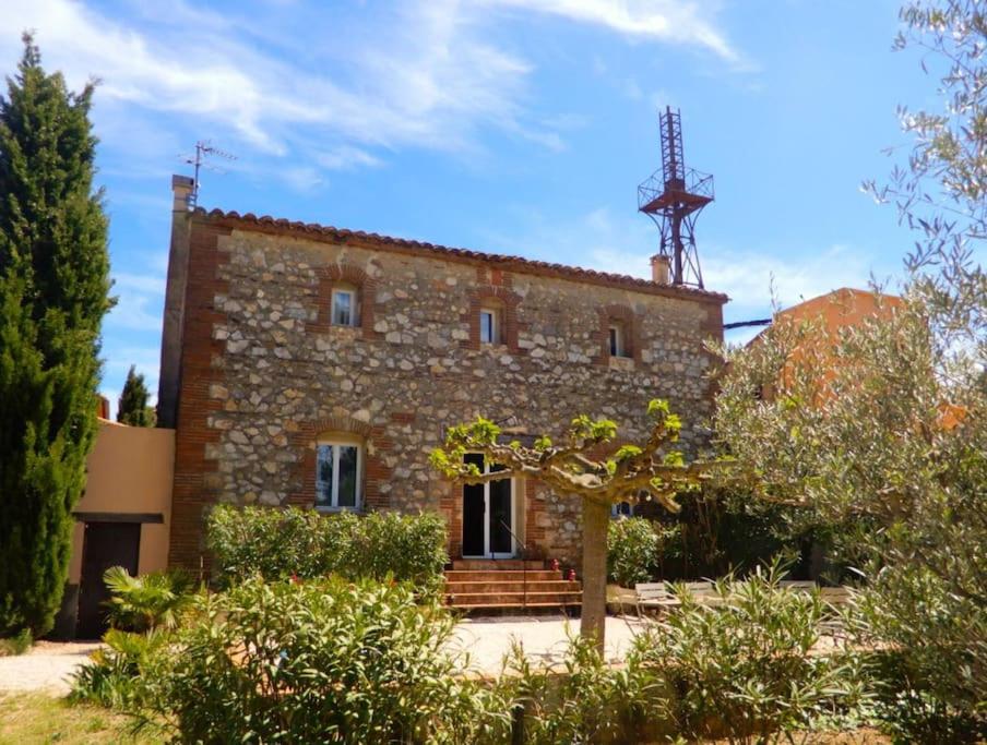 stary kamienny dom z wieżą na górze w obiekcie La maison des vendangeurs w mieście Canet-en-Roussillon