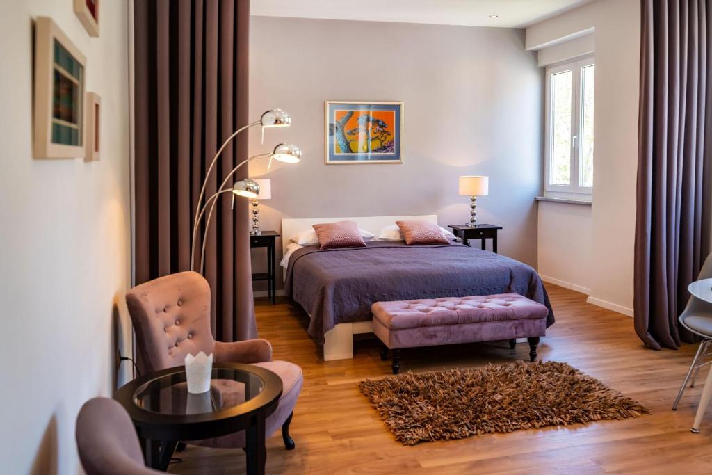 ein Schlafzimmer mit einem Bett, einem Stuhl und einem Tisch in der Unterkunft Studio Apartment Jader in Zadar