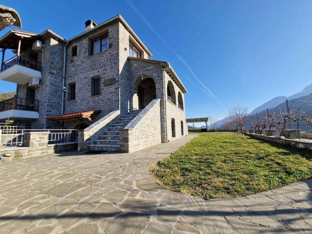 a large stone building with a grassy field in front of it at The Stone House in Përmet