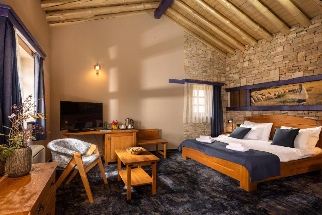 1 dormitorio con 1 cama grande y pared de ladrillo en Herceg Etno Selo Međugorje, en Međugorje