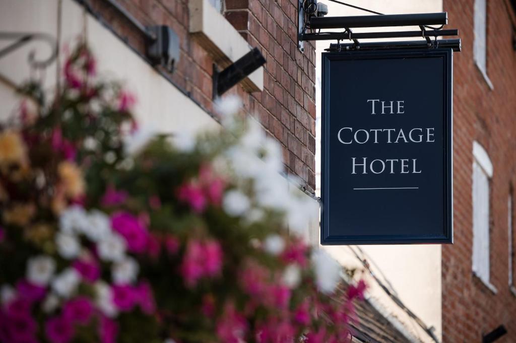 a sign that reads the coffee hotel hanging on a building at The Cottage Hotel in Nottingham