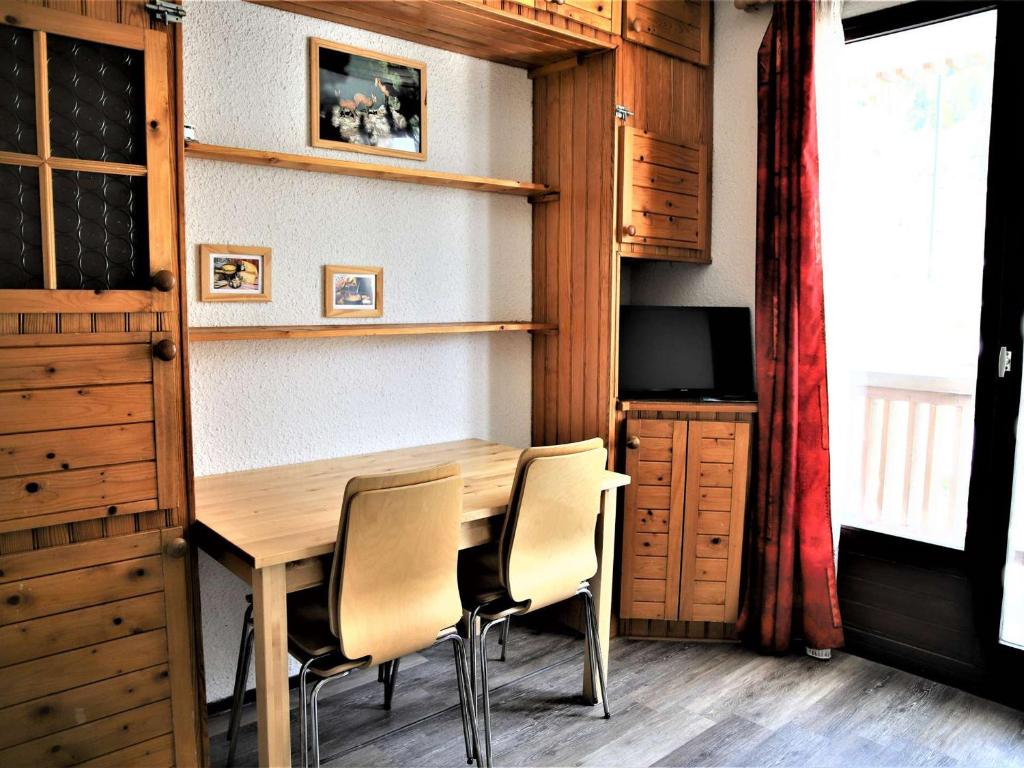 ein Esszimmer mit einem Holztisch und Stühlen in der Unterkunft Appartement Auris, 2 pièces, 3 personnes - FR-1-297-40 in Auris