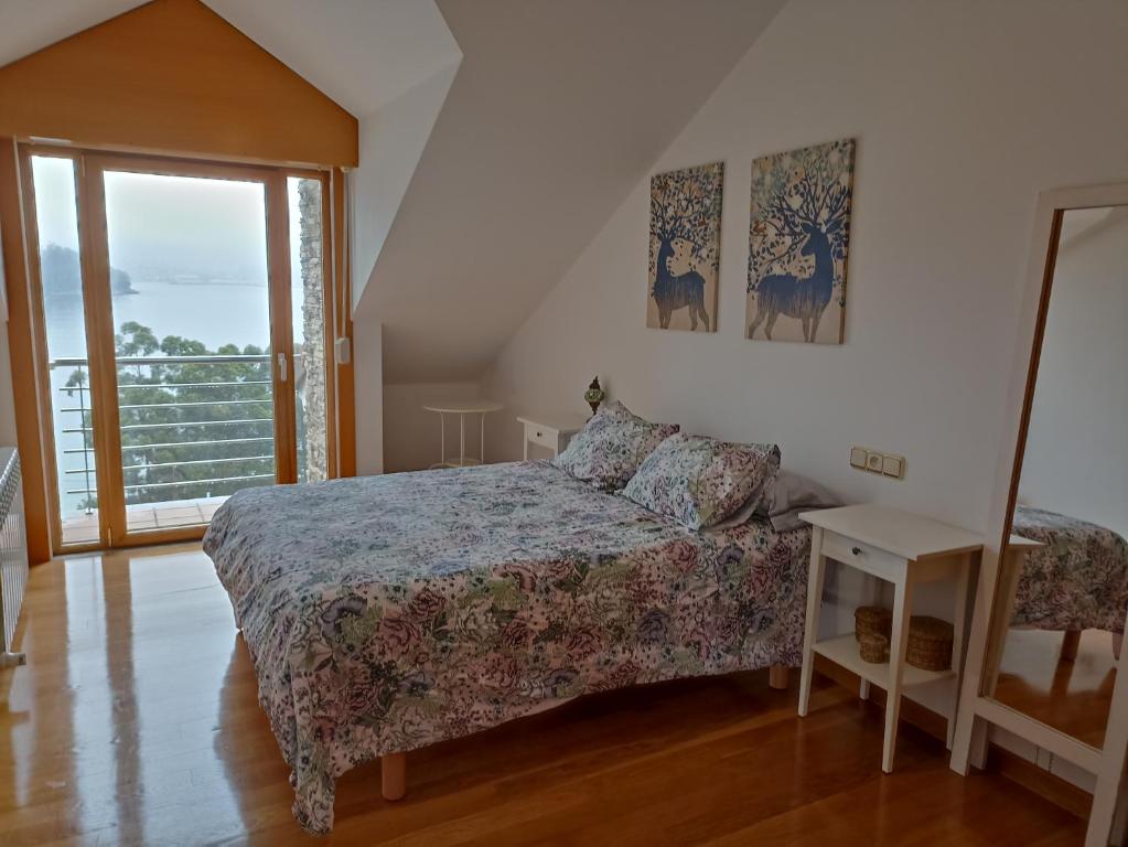 1 dormitorio con cama y ventana en Chalet en Combarro a pie de playa, en Poio