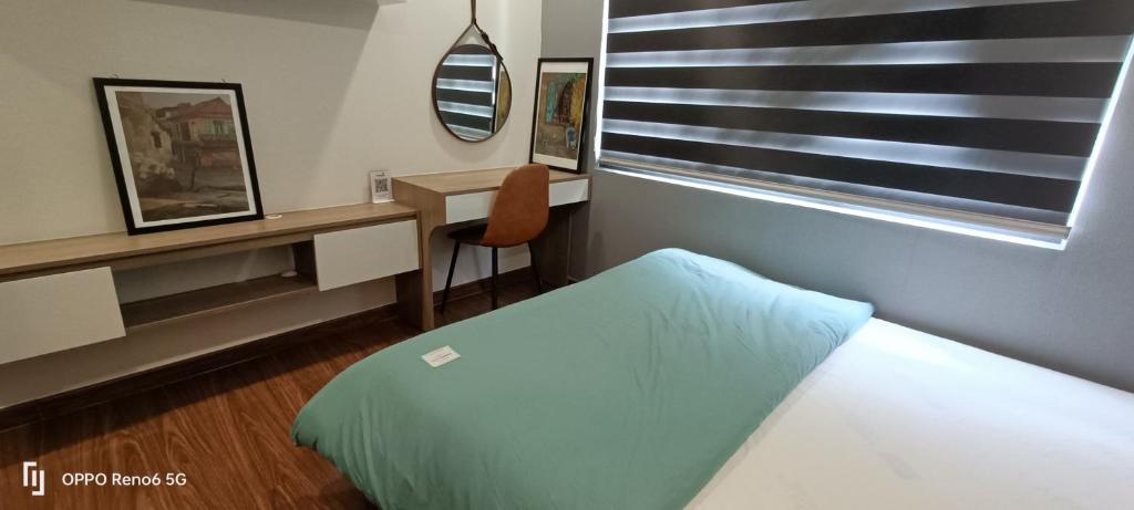 1 dormitorio con cama, escritorio y ventana en Homestay căn hộ Mẹ Khang, en Dĩ An