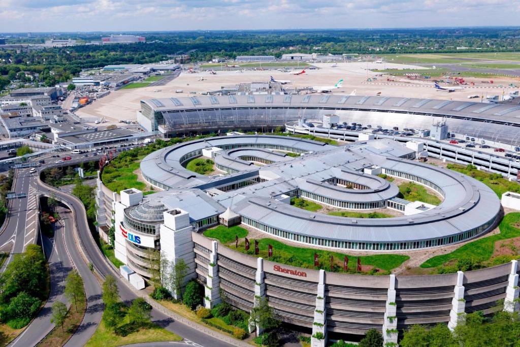 eine Luftansicht eines großen Gebäudes mit einer Straße in der Unterkunft Sheraton Duesseldorf Airport Hotel in Düsseldorf