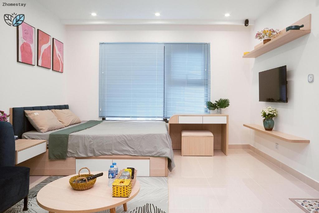 une chambre avec un lit, un canapé et une télévision dans l'établissement Vinhomes Smartcity-Căn hộ dich vụ -Zhomestay, à Thượng Thôn