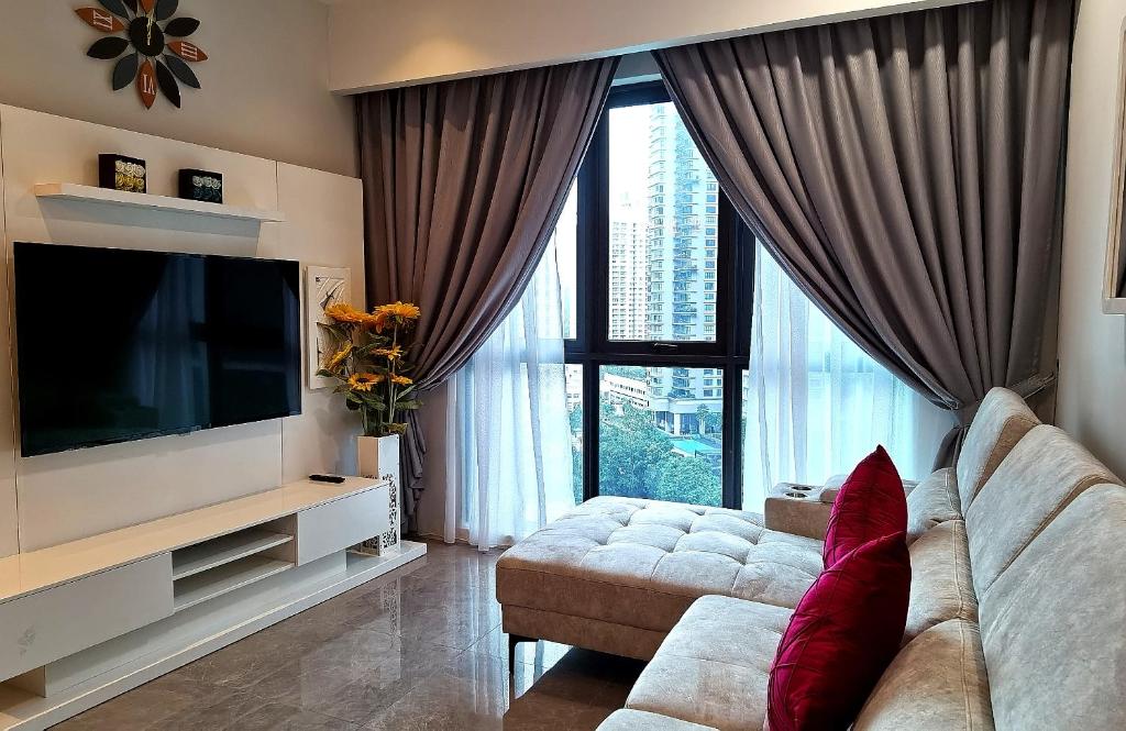 a living room with a couch and a flat screen tv at The Ooak Suites, Kiara 163 by Bamboo Hospitality in Kuala Lumpur