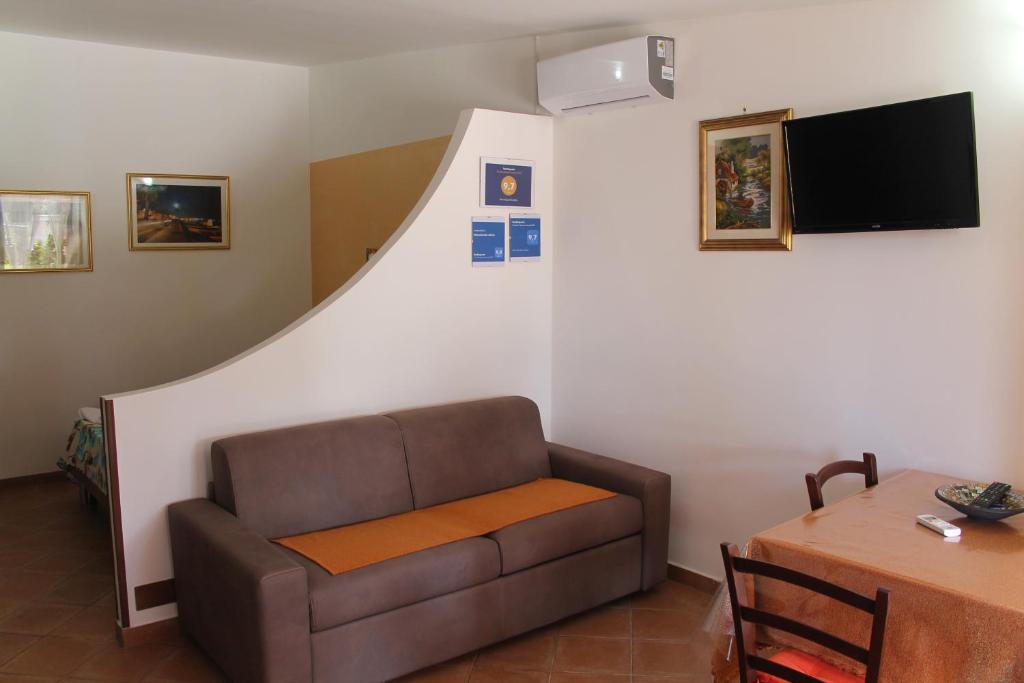 uma sala de estar com um sofá e uma mesa em Monolocale Letizia em Porto Cesareo