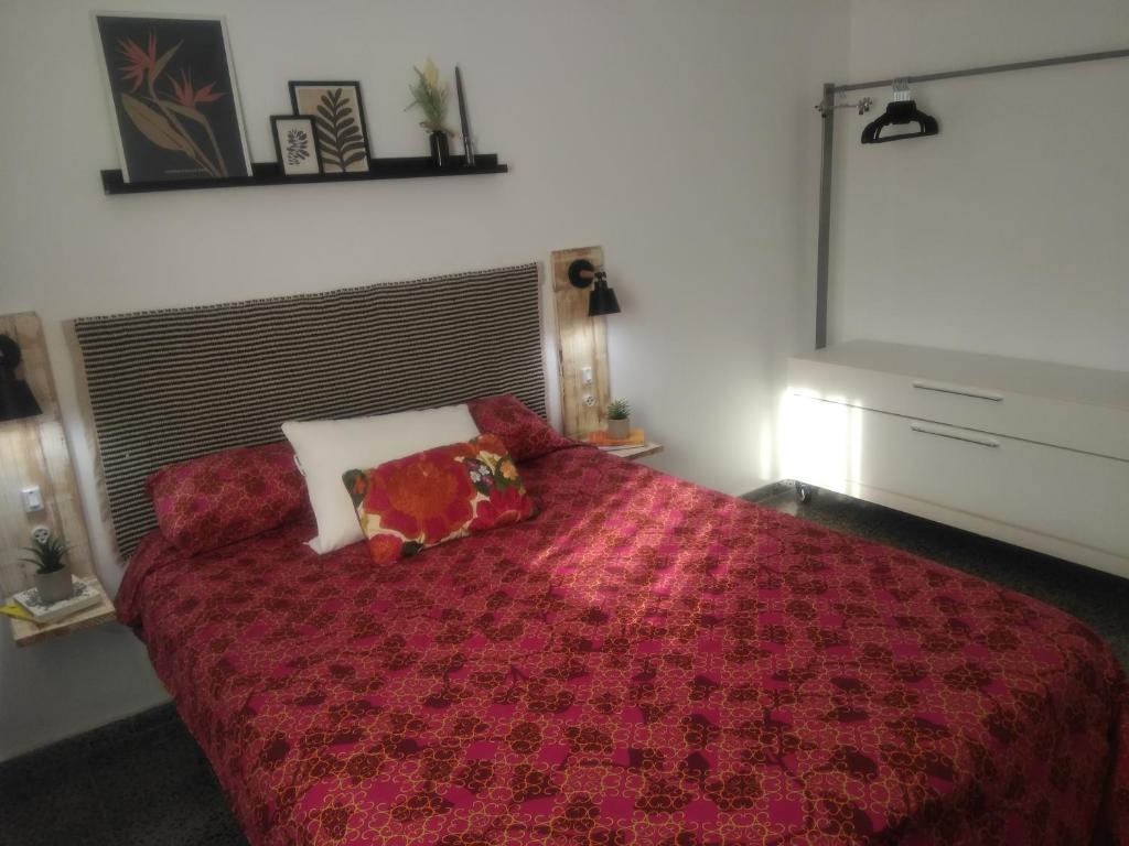a bedroom with a red bed with two pillows on it at Sevilla Macarena apartamento 3 dormitorios in Seville