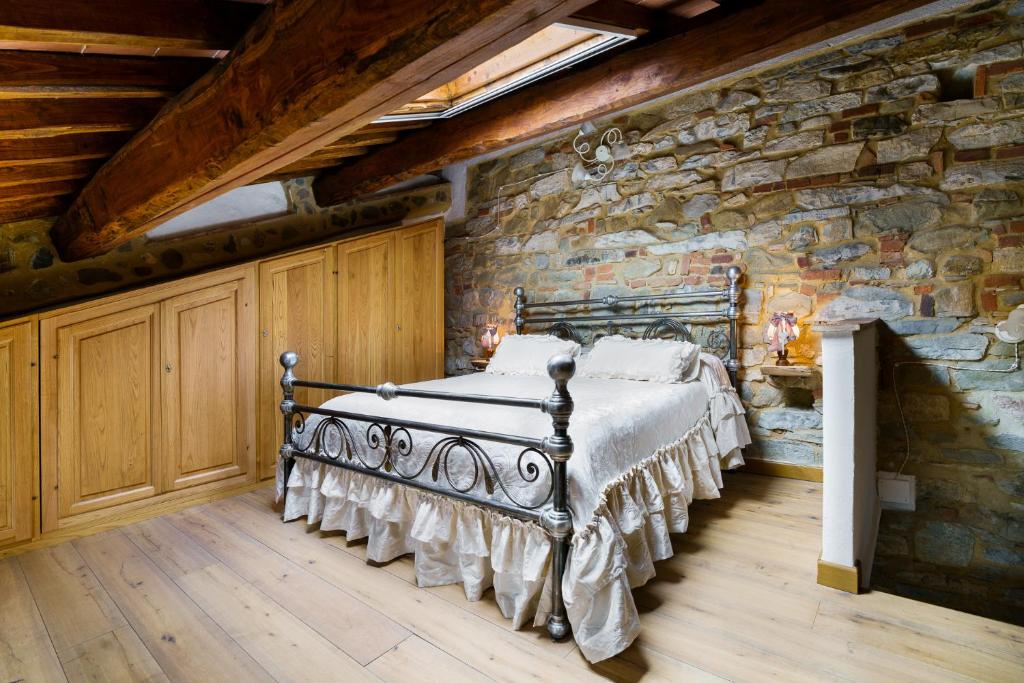 una camera con un letto in una parete in pietra di La Casetta Nel Borgo a Castelnuovo di Val di Cecina