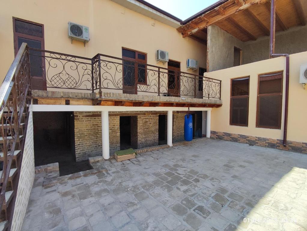 an empty courtyard of a house with a balcony at Sezam in Bukhara