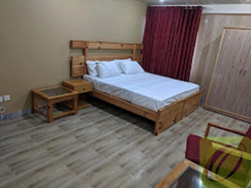a bedroom with a large bed and a table at Heavess Peak Hotel in Muzaffarabad