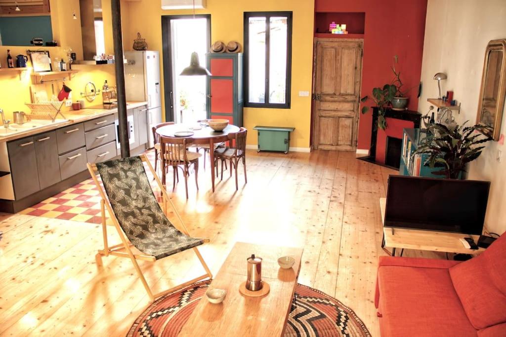 Artistic Loft, Downtown Montpellier, WIFI في مونبلييه: مطبخ وغرفة معيشة مع طاولة وكراسي