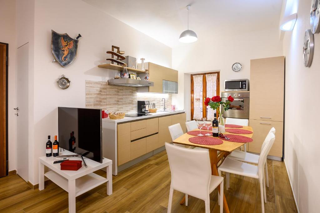 una cucina e una sala da pranzo con tavolo e sedie di Lady Camollia Apartment a Siena