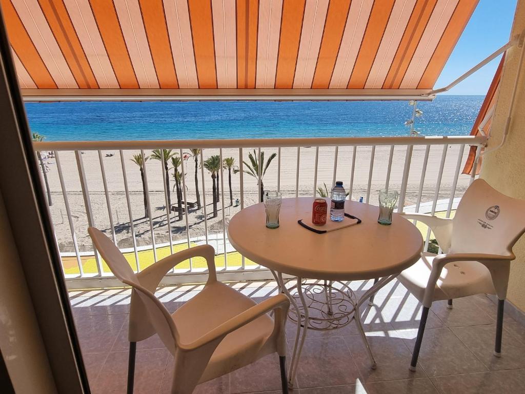 a table and chairs in a balcony with a view of the ocean at Benidorm's Beach in Benidorm