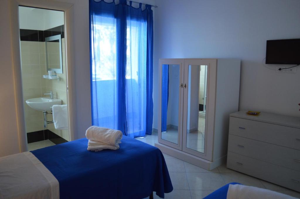 a bedroom with a bed and a sink and a mirror at B&B Le Tre Stelle in Milazzo