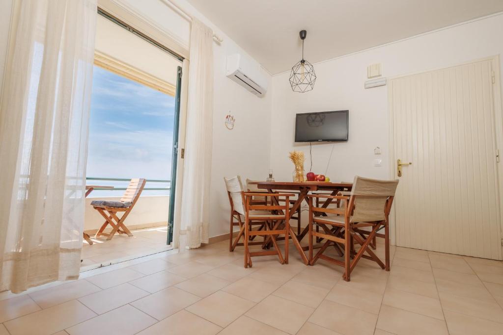 A television and/or entertainment centre at Kallopsia - Glifada Beach Menigos Resort by New Era