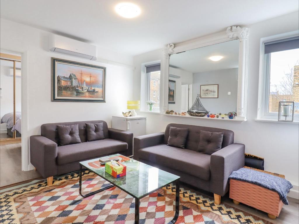 a living room with two couches and a coffee table at Sherwood Apartment in Margate