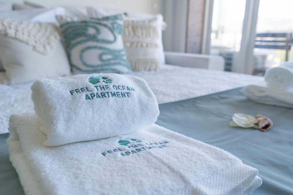una pila de toallas sentadas encima de una cama en Feel The Ocean Apartment Praia do Cabedelo, en Viana do Castelo