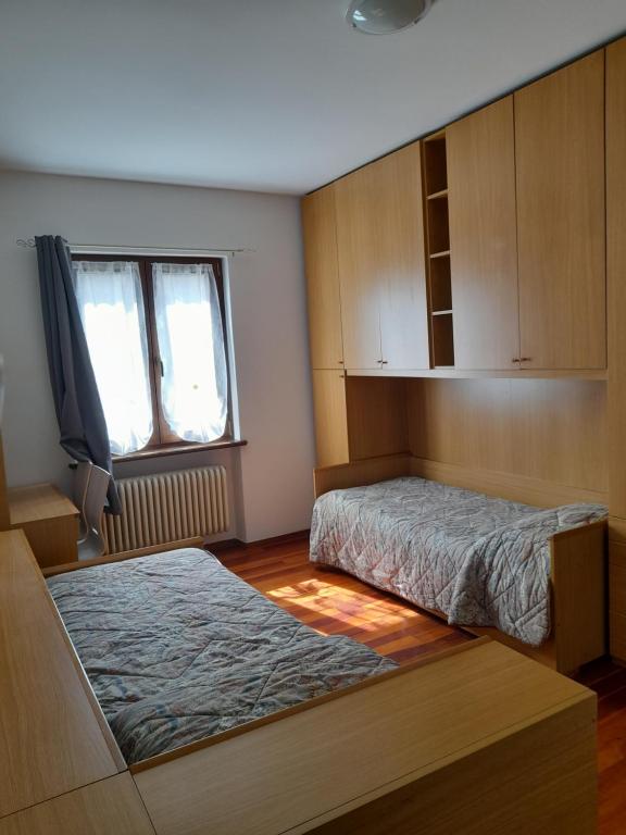 een slaapkamer met 2 bedden en een tv. bij Casa Firmina Appartamento Santa Maria Maggiore in Santa Maria Maggiore