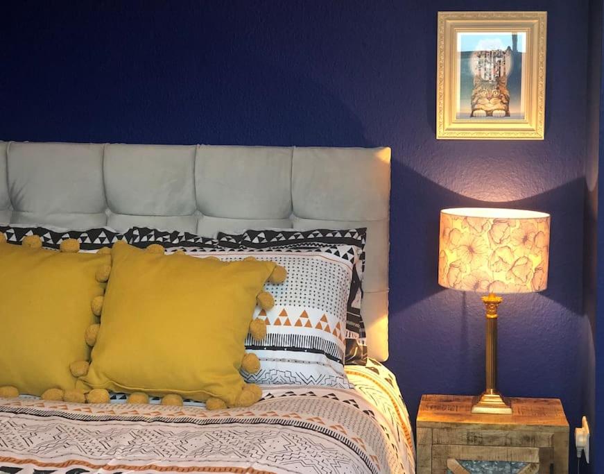 a bedroom with a bed with yellow pillows and a lamp at Lido's View in Bristol