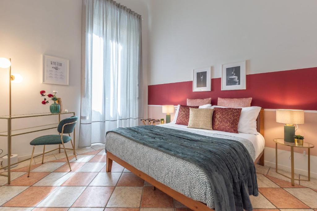 フィレンツェにあるWine Apartments Florence Pinotの赤い壁のベッドルーム1室(大型ベッド1台付)