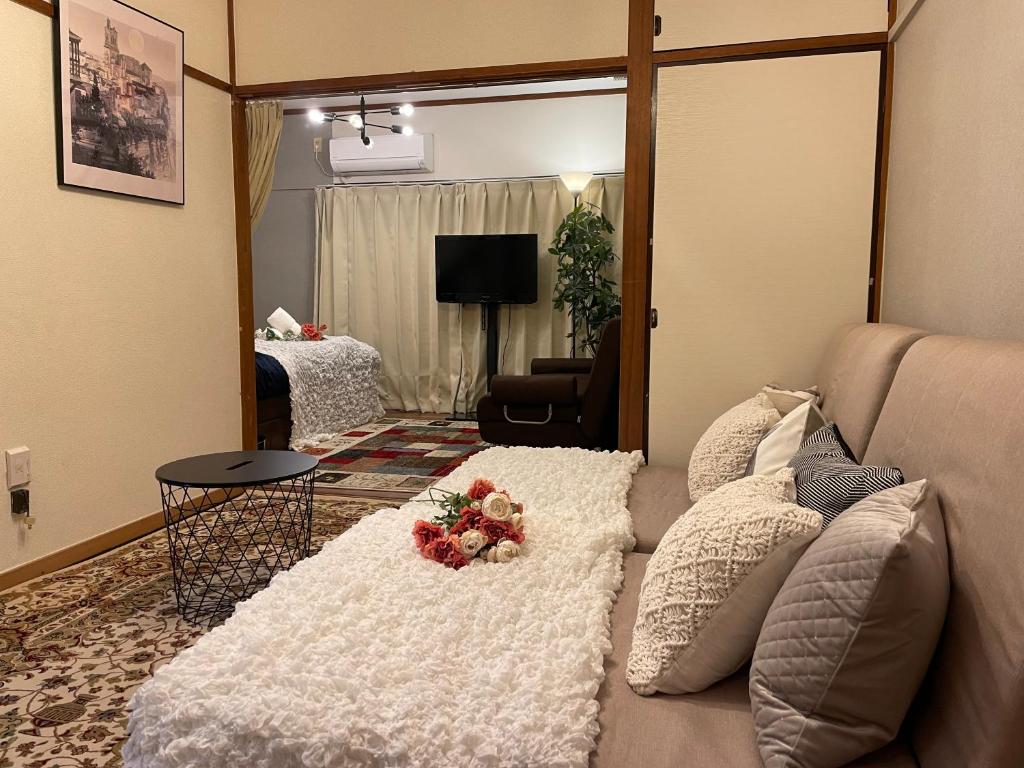 a living room with a couch in front of a mirror at Best Shinjuku Modern Full-furnished Family size Apartment4 ONLY 2min to Shinjuku by Train in Tokyo