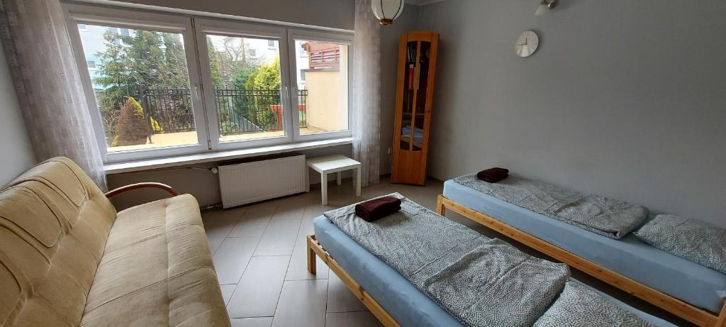 Pokój z 2 łóżkami, kanapą i oknem w obiekcie Nad Morzem w Gdańsku