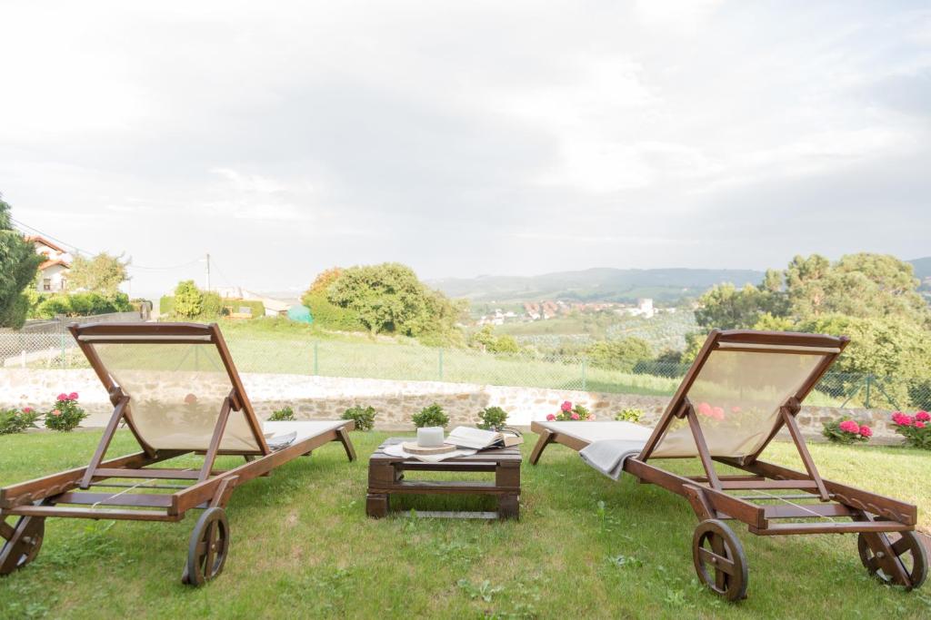 dwa krzesła i stół w trawie w obiekcie Apartamentos Nordeste w mieście Trasierra