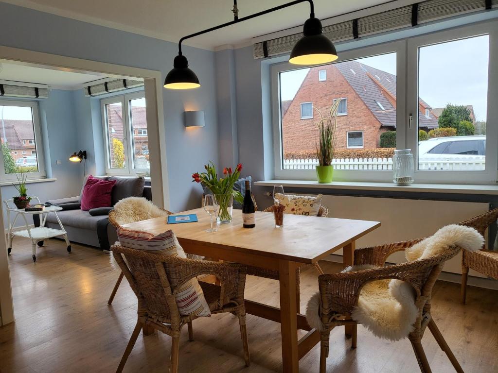 - un salon avec une table et des chaises en bois dans l'établissement Ferienhaus Annas Garten, à Sankt Peter-Ording