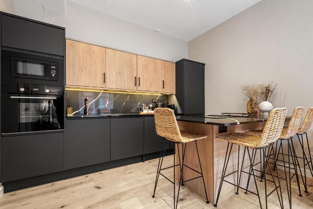 cocina con electrodomésticos negros y mesa de madera en Stylish 1 Bed City Centre Apartment (Sleeps 4) en Newcastle