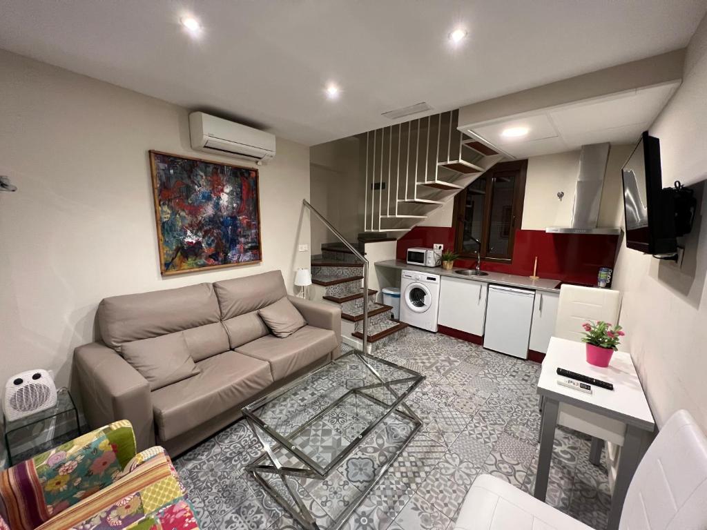 sala de estar con sofá y cocina en Apartamentos Royal Urban Granada, en Granada