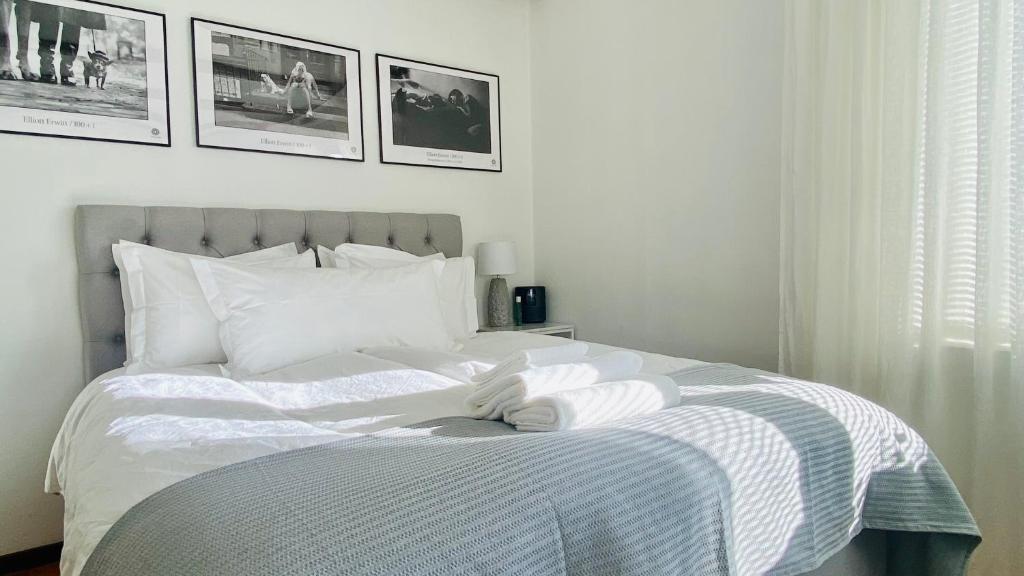 a bedroom with a white bed with pictures on the wall at Sundsvall by M - Apartment in Sundsvall