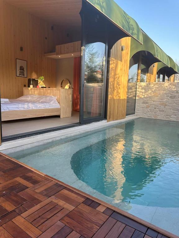 a swimming pool in front of a house with a bed at PRİME SUİTES in Yalova