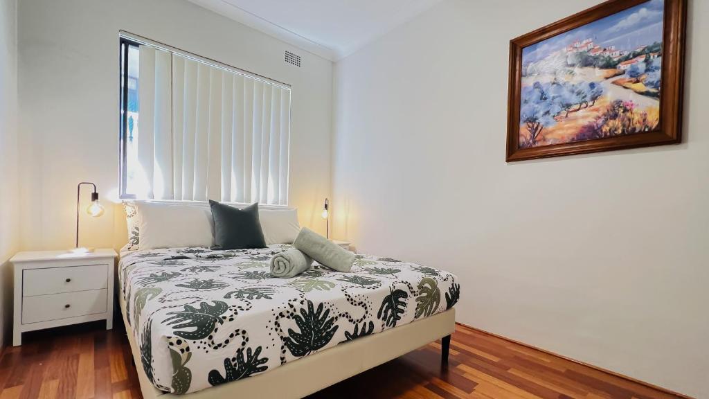een slaapkamer met een bed en een foto aan de muur bij Carlton 3 beds unit - free parking in Sydney