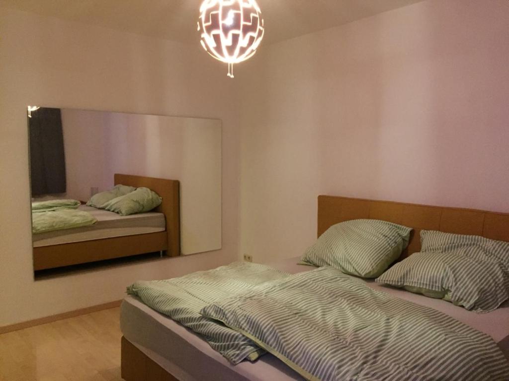 1 dormitorio con 2 camas, espejo y lámpara de araña en Apartment mit 2 Schlafzimmern in Dresdner Neustadt en Dresden