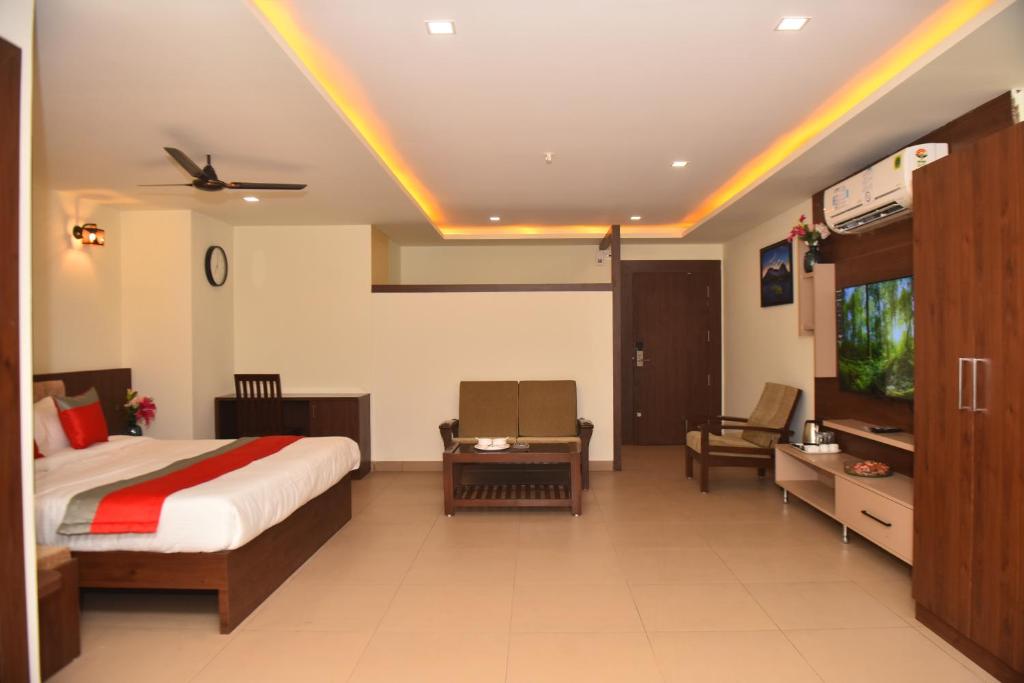 M R Residency Dharwad. في دهرواد: غرفة فندق بسرير وتلفزيون